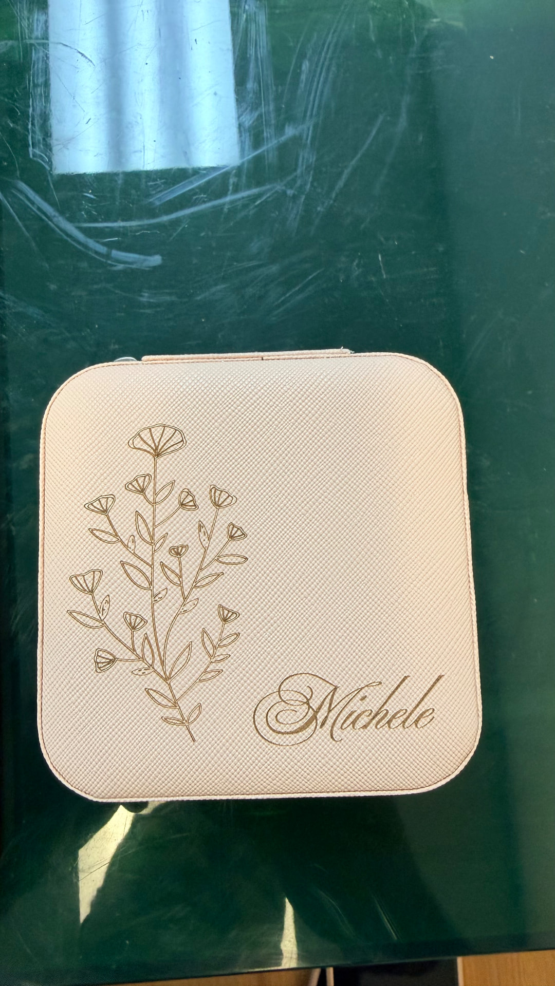 Floral design and name engraved on a travel jewelry case