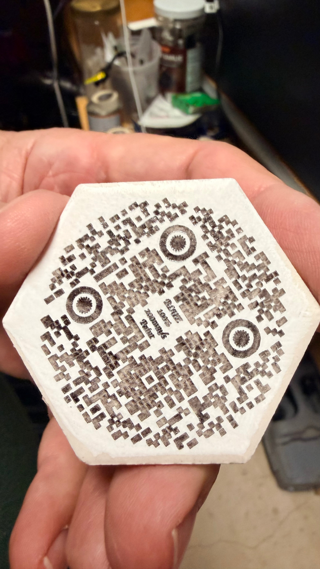 QR code engraved into a hex stone tile